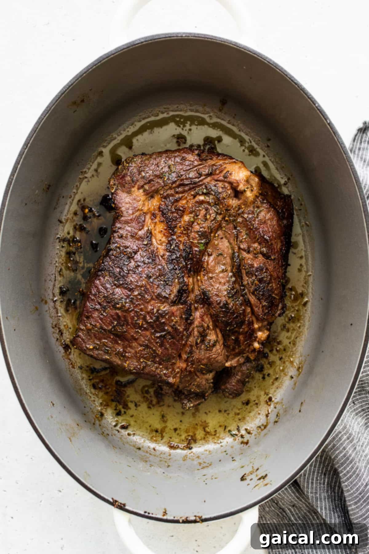 The Importance of Searing for a Flavorful Pot Roast A robustly seared chuck roast, boasting a golden-brown crust, cooking in a Dutch oven with a small amount of oil. This initial sear is key for deep flavor development.