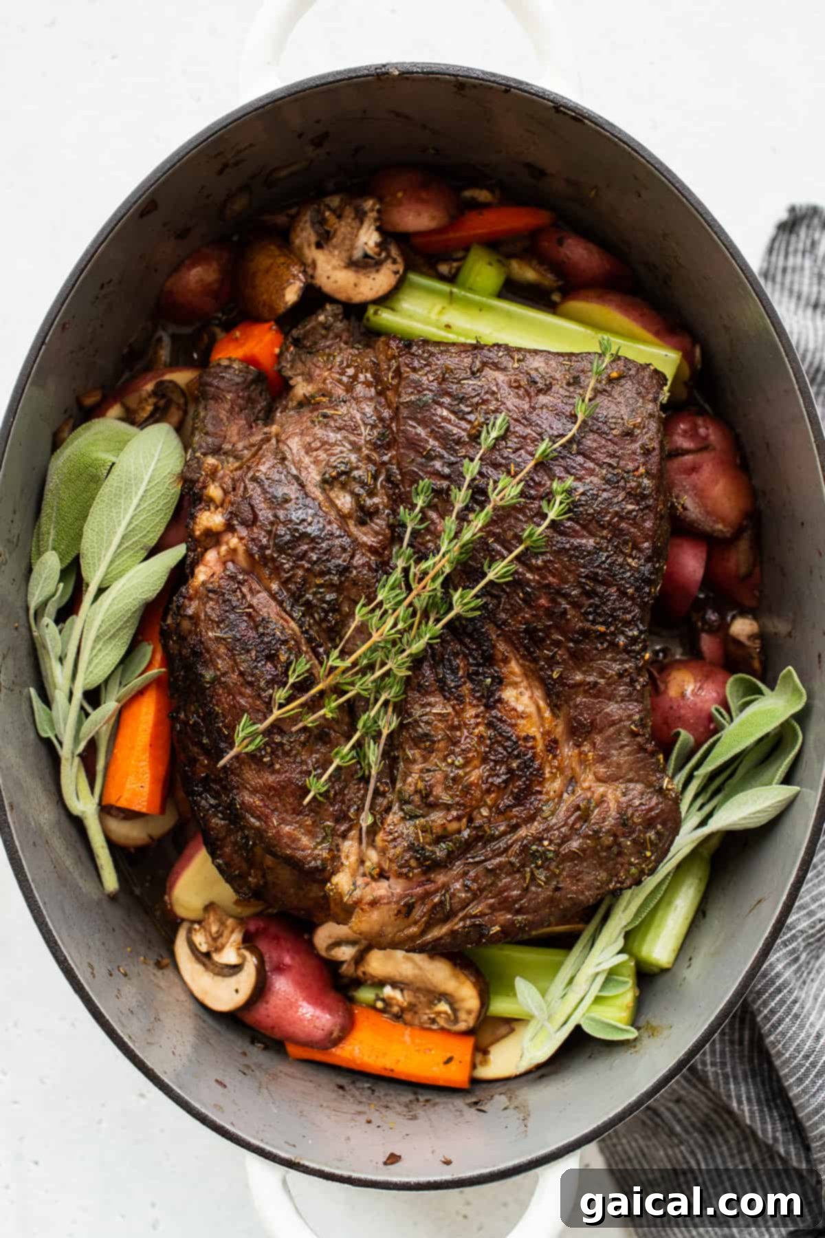 Garnished Dutch Oven Pot Roast: A Visual Feast A hearty Dutch oven pot roast, beautifully cooked and topped with fresh rosemary and thyme sprigs, showcasing the tender meat and vibrant vegetables submerged in a rich broth, ready to be served.