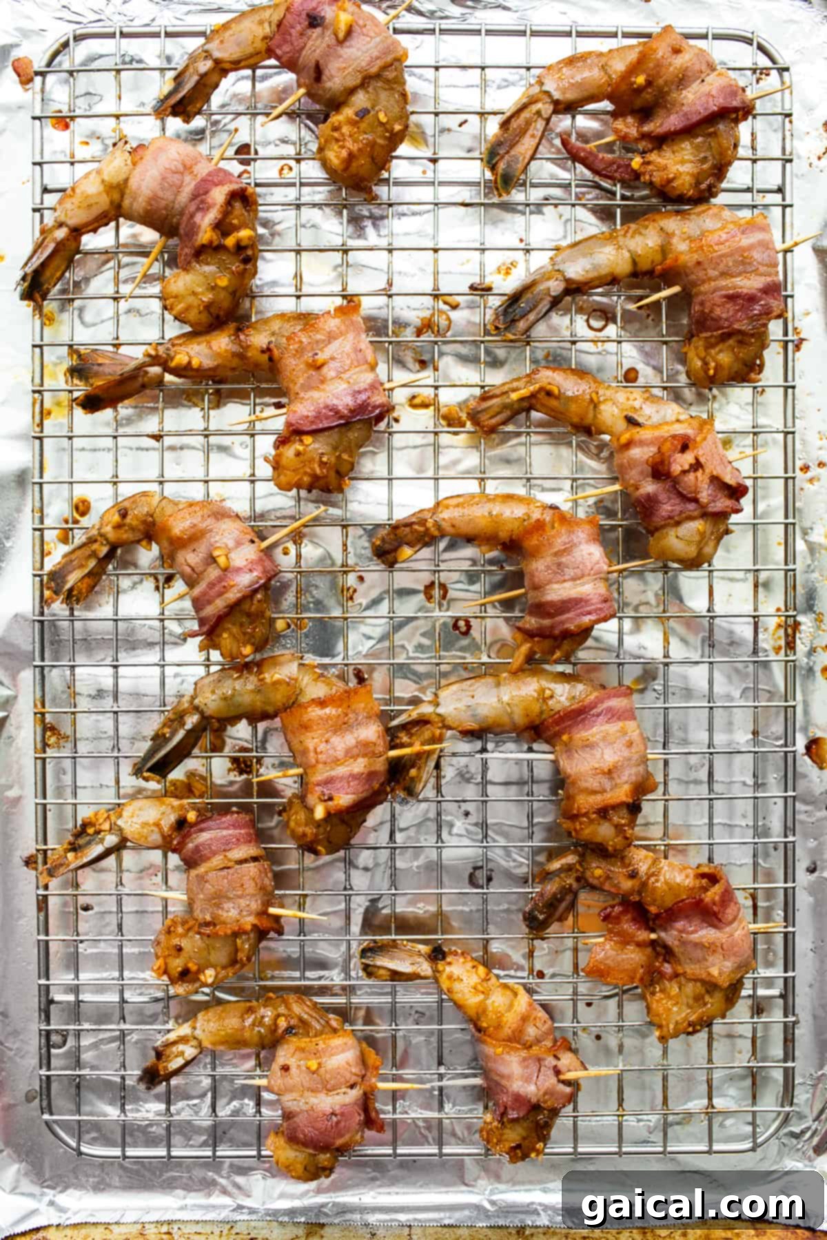 Bacon Wrapped Shrimp Baking to Golden Perfection Partially cooked bacon-wrapped shrimp on a baking sheet, ready for final baking.