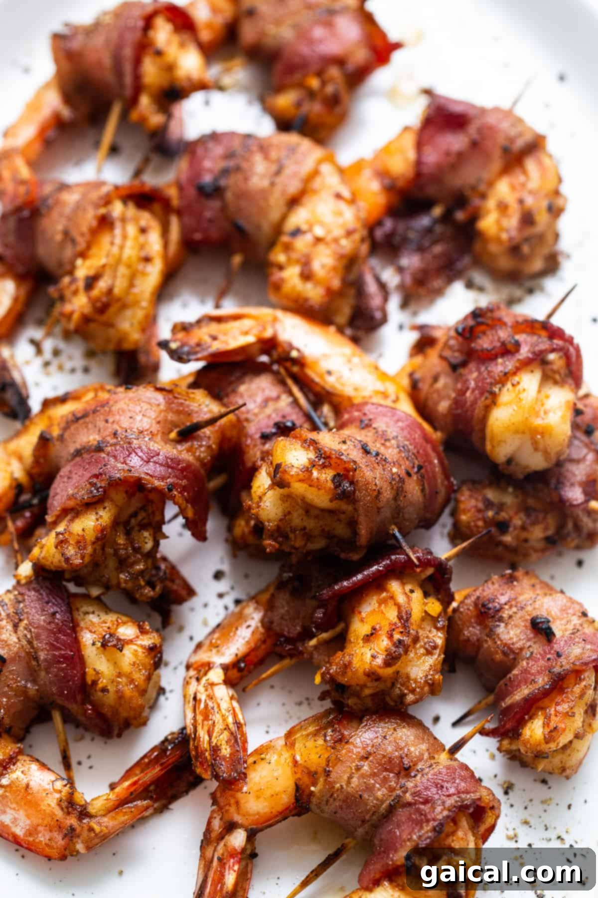 Exquisite Bacon Wrapped Shrimp Appetizer Presentation Bacon wrapped shrimp presented beautifully on a pristine white serving platter.