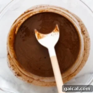 Melted chocolate and coconut oil in a bowl, showing smooth consistency.