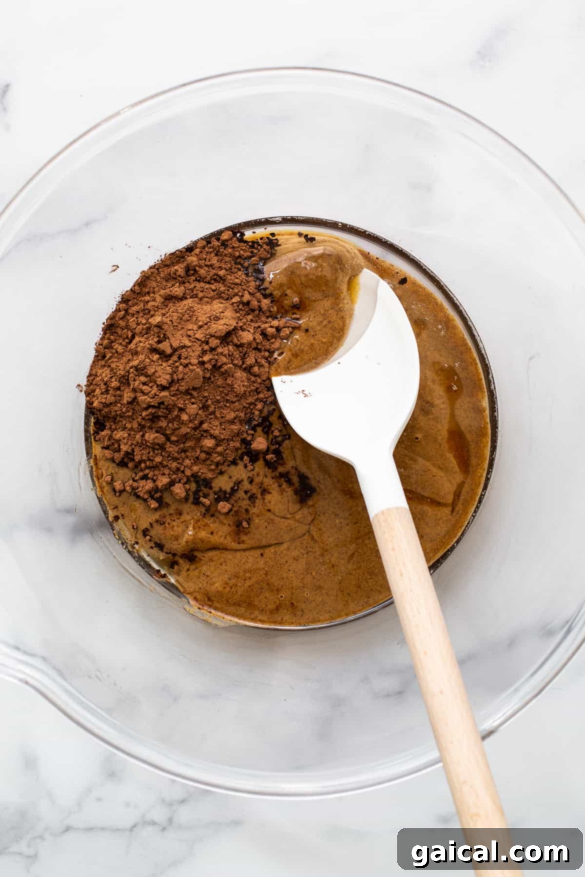 Arctic Peppermint Fudge 3 Key ingredients for peppermint freezer fudge, including almond butter, cocoa powder, coconut oil, and peppermint extract, arranged in a bowl.