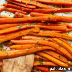 Carrots on a baking sheet with a wooden spoon.