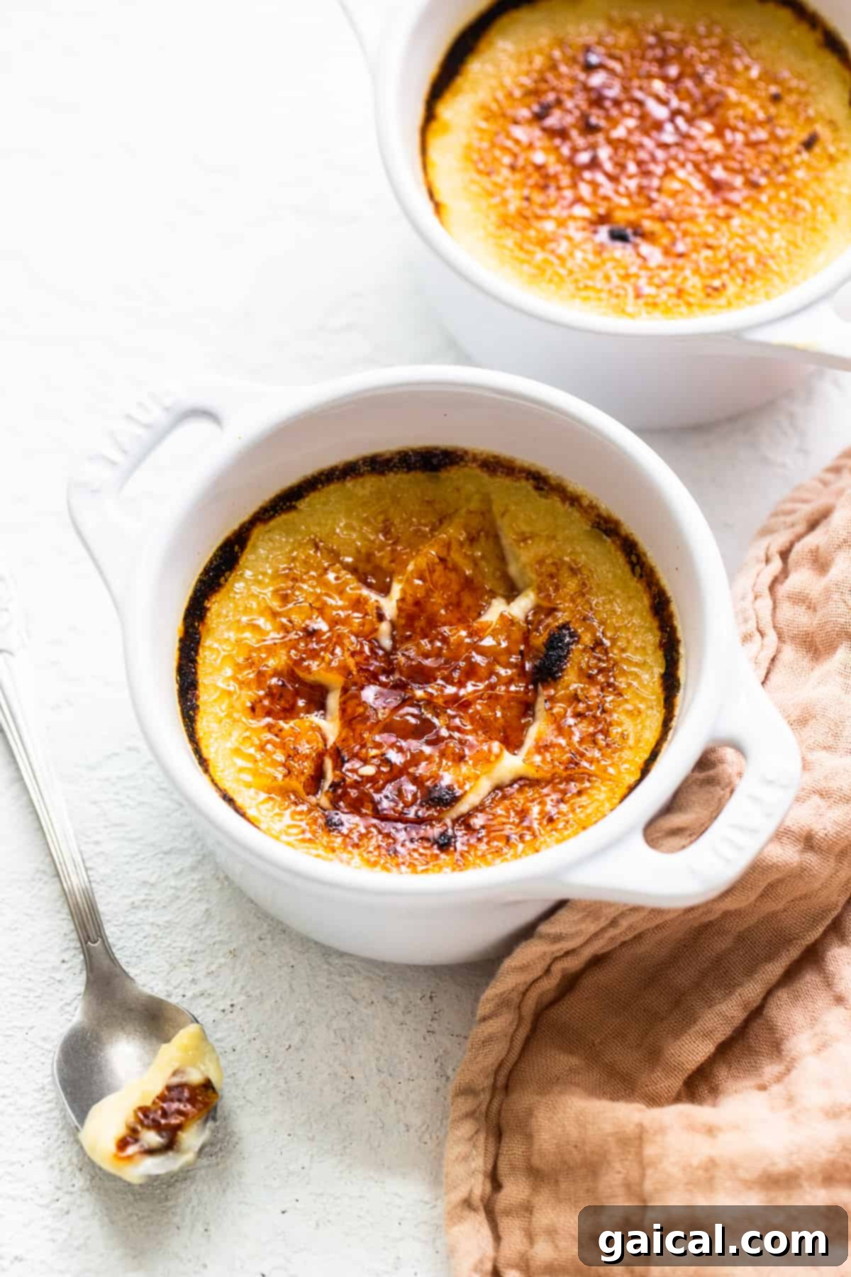 Spiced Eggnog Crème Brûlée 2 Eggnog Crème Brûlée with a perfectly cracked sugar top, ready to be enjoyed.