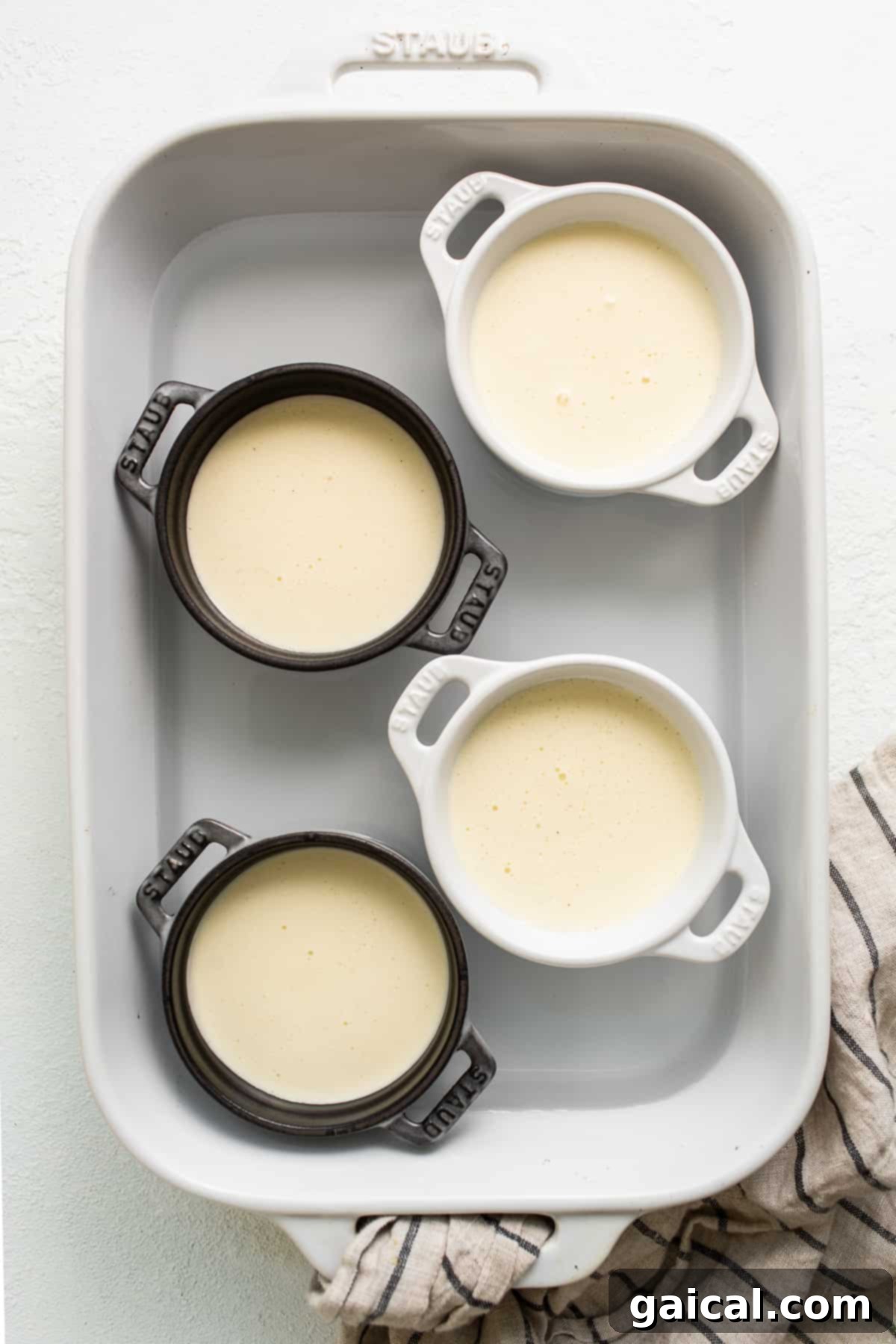 Spiced Eggnog Crème Brûlée 6 Eggnog crème brûlée mixture evenly distributed in ramekins, ready for the oven.