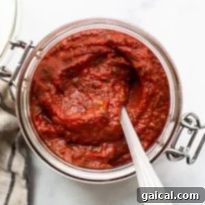 Crispy Baguette Pizza 2 A jar of homemade pizza sauce with fresh herbs.