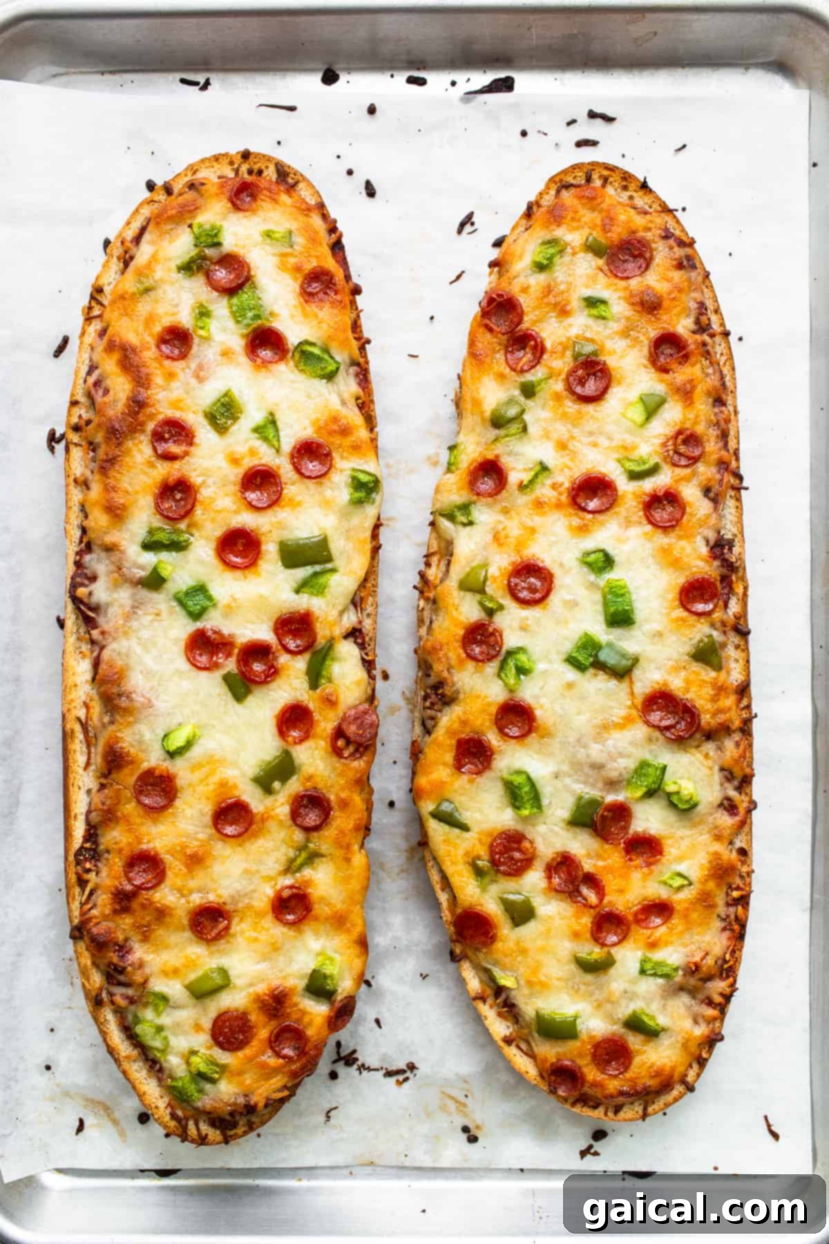 Freshly Baked French Bread Pizza with Golden Crust Two halves of perfectly cooked French bread pizza on a baking sheet, with bubbly cheese and crisp edges.