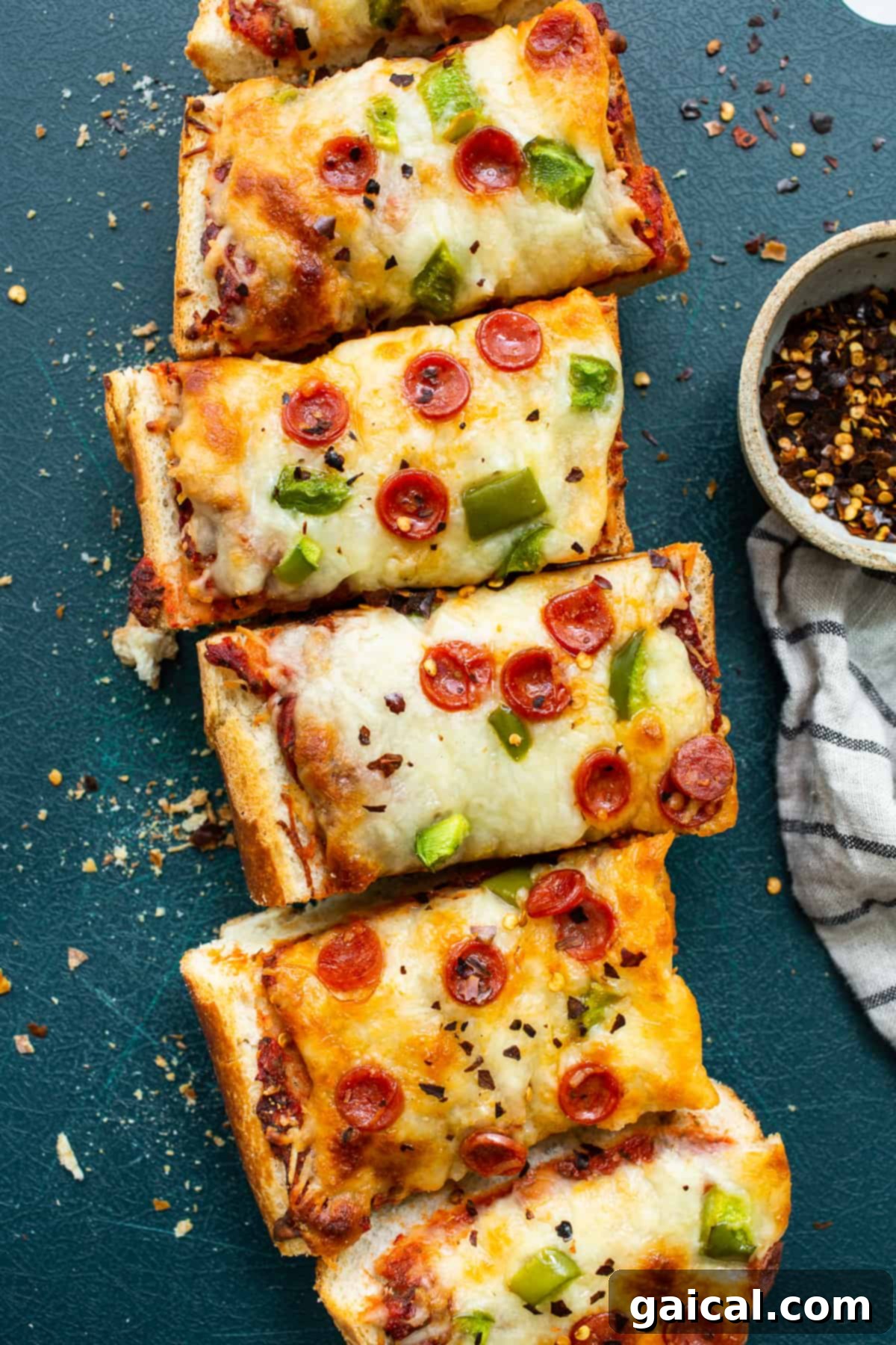 Perfectly Sliced French Bread Pizza for Easy Serving Slices of French bread pizza arranged neatly on a wooden cutting board, garnished with fresh basil.