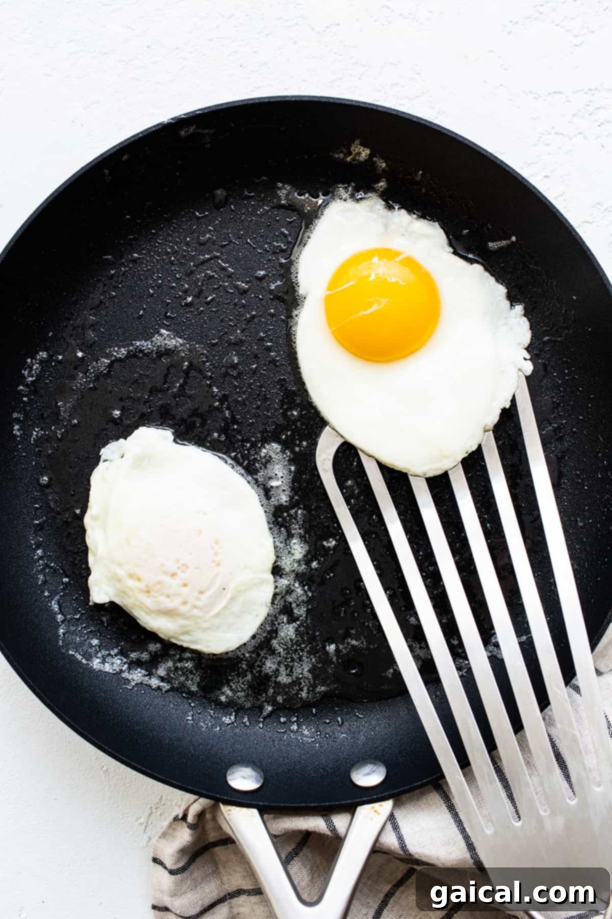 Liquid Gold Breakfast 5 Two eggs expertly flipped and cooking in a skillet.