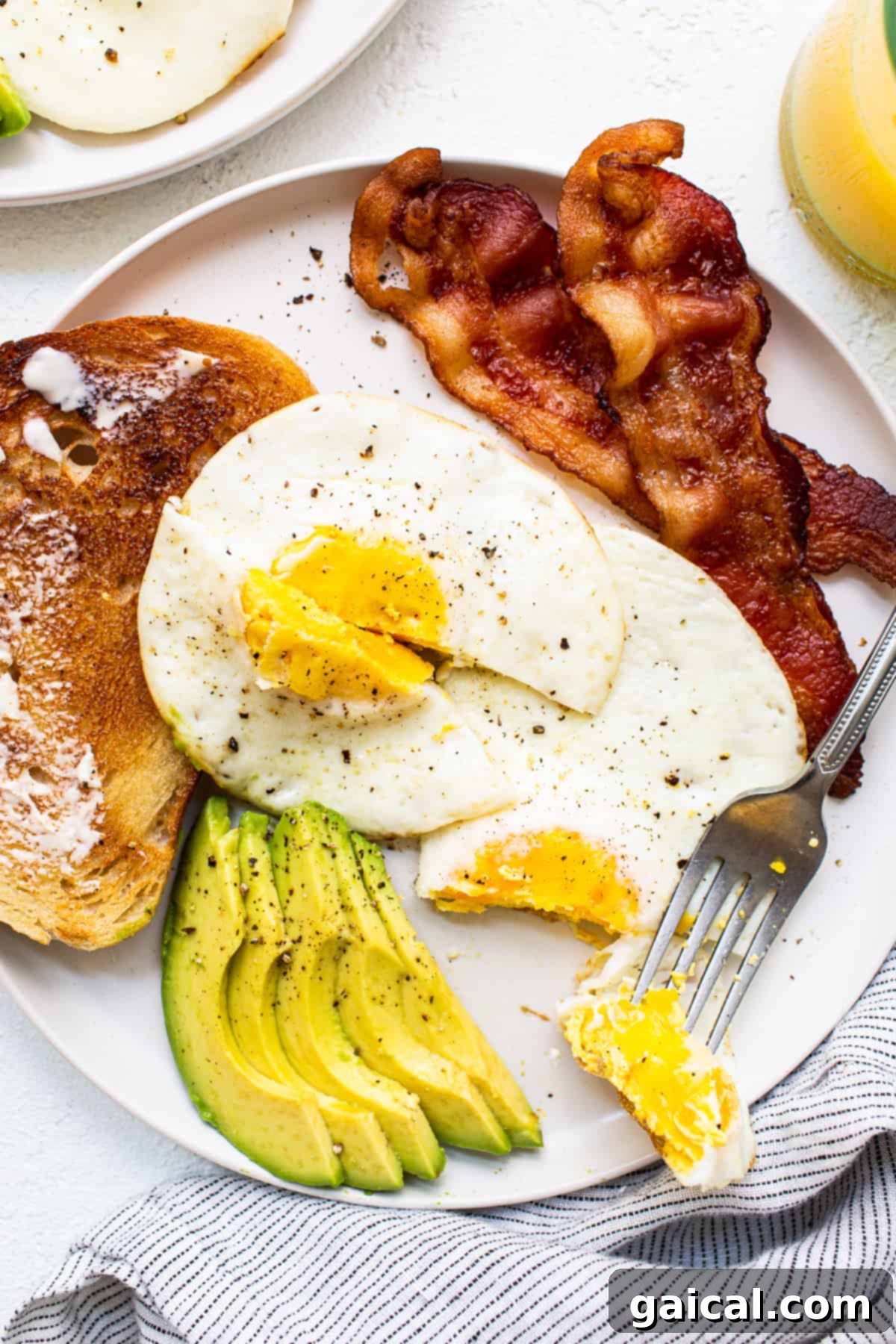 A perfectly cooked over hard egg resting on a pristine white plate, ready to be enjoyed as part of a delicious breakfast.