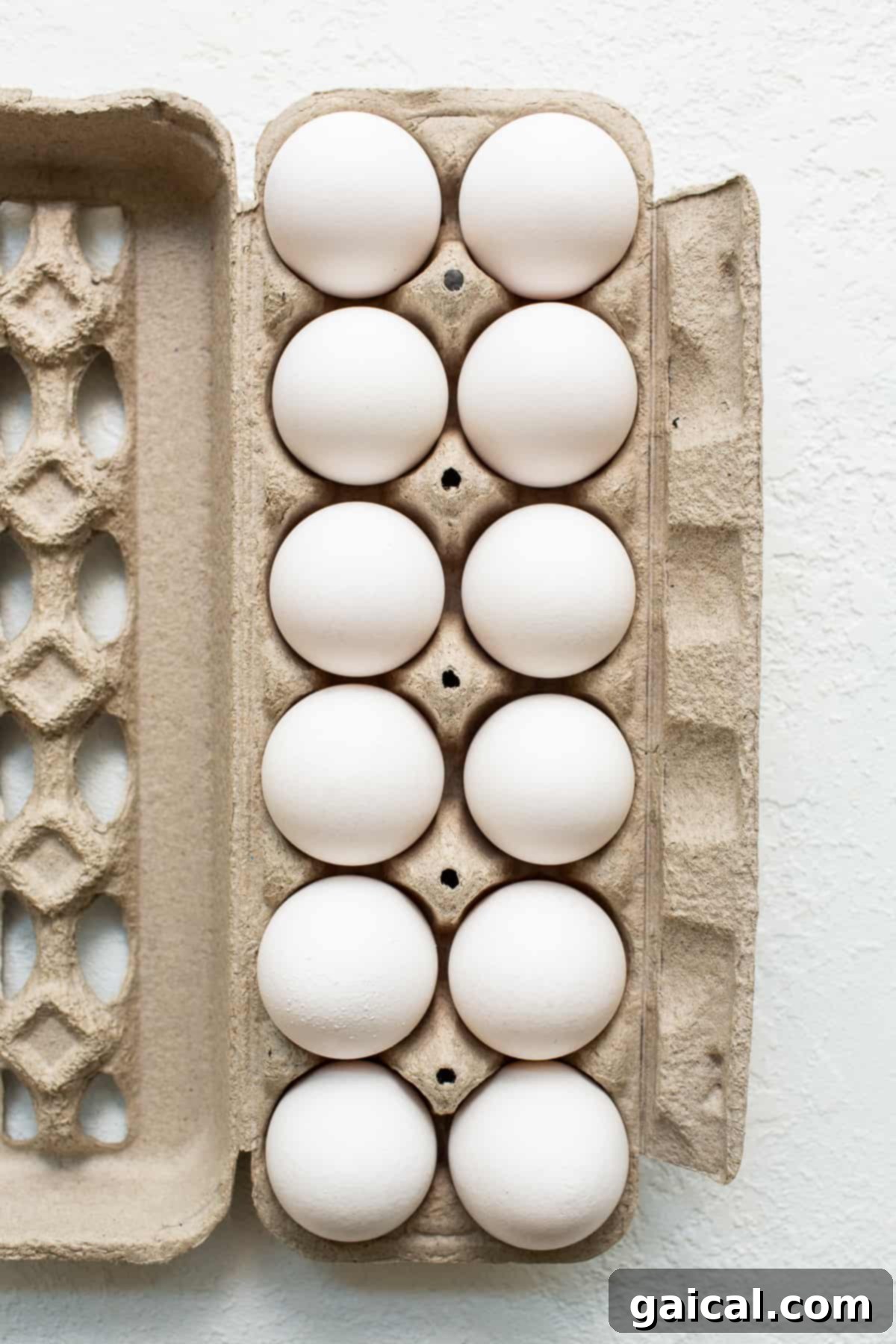 A brown carton overflowing with fresh, large eggs, symbolizing the primary ingredient for a wholesome breakfast.