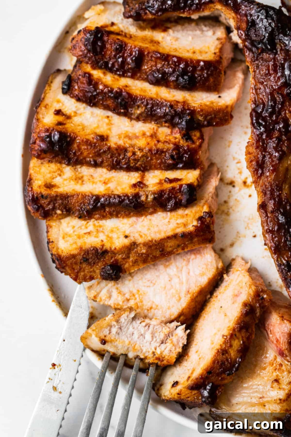 Sliced Air Fryer Pork Chops Beautifully sliced, juicy air fryer pork chops arranged on a white plate.
