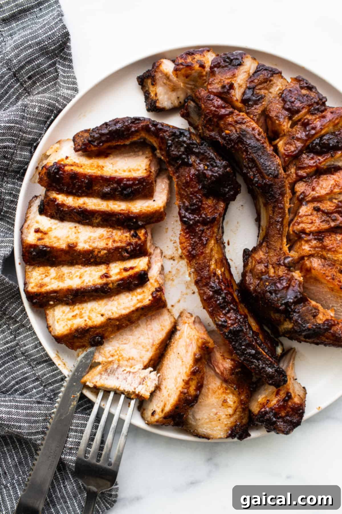 Served Air Fryer Pork Chops Perfectly cooked, sliced air fryer pork chops on a plate with garnishes.