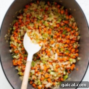 Minced onions, carrots, and celery sautéing in a stock pot, forming the aromatic base for bolognese.