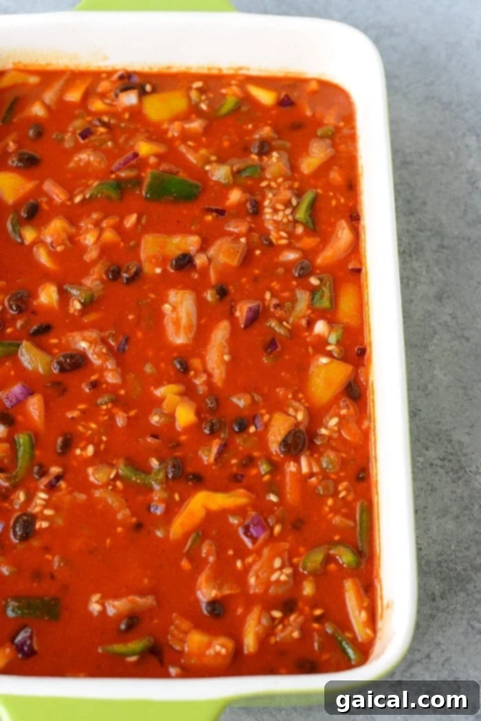 In just 60 minutes you can make this healthy chicken enchilada casserole that's packed with lean chicken, beans, tons of veggies, and brown rice. Throw everything into a casserole dish uncooked (that's right...UNCOOKED) and you've got yourself dinner for the entire family.