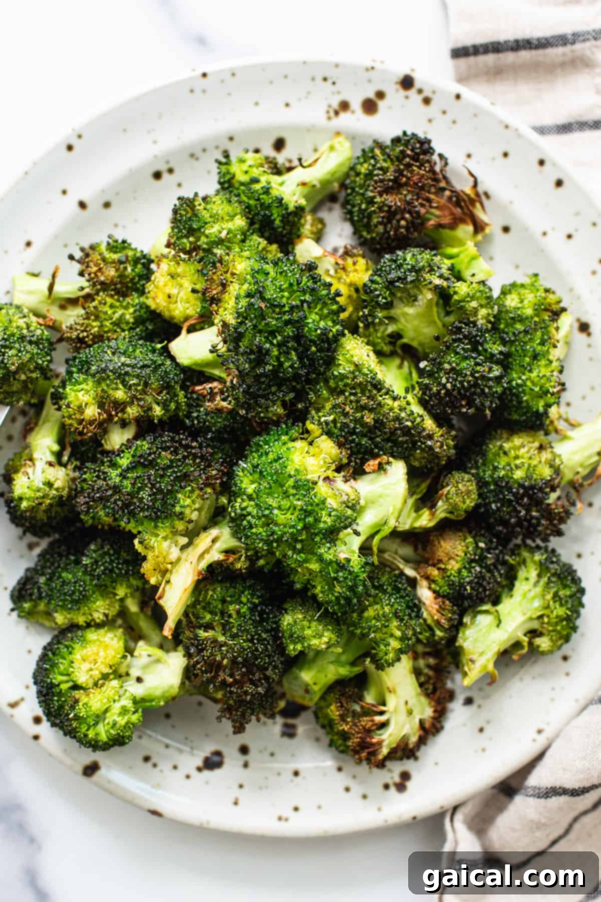 Crispy Air Fryer Broccoli florets served on a rustic plate, ready to eat.