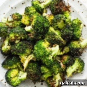A serving of finished air fryer broccoli on a plate, garnished and ready to be enjoyed.