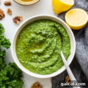 Creamy homemade kale pesto beautifully presented in a small bowl, garnished with a fresh kale leaf.