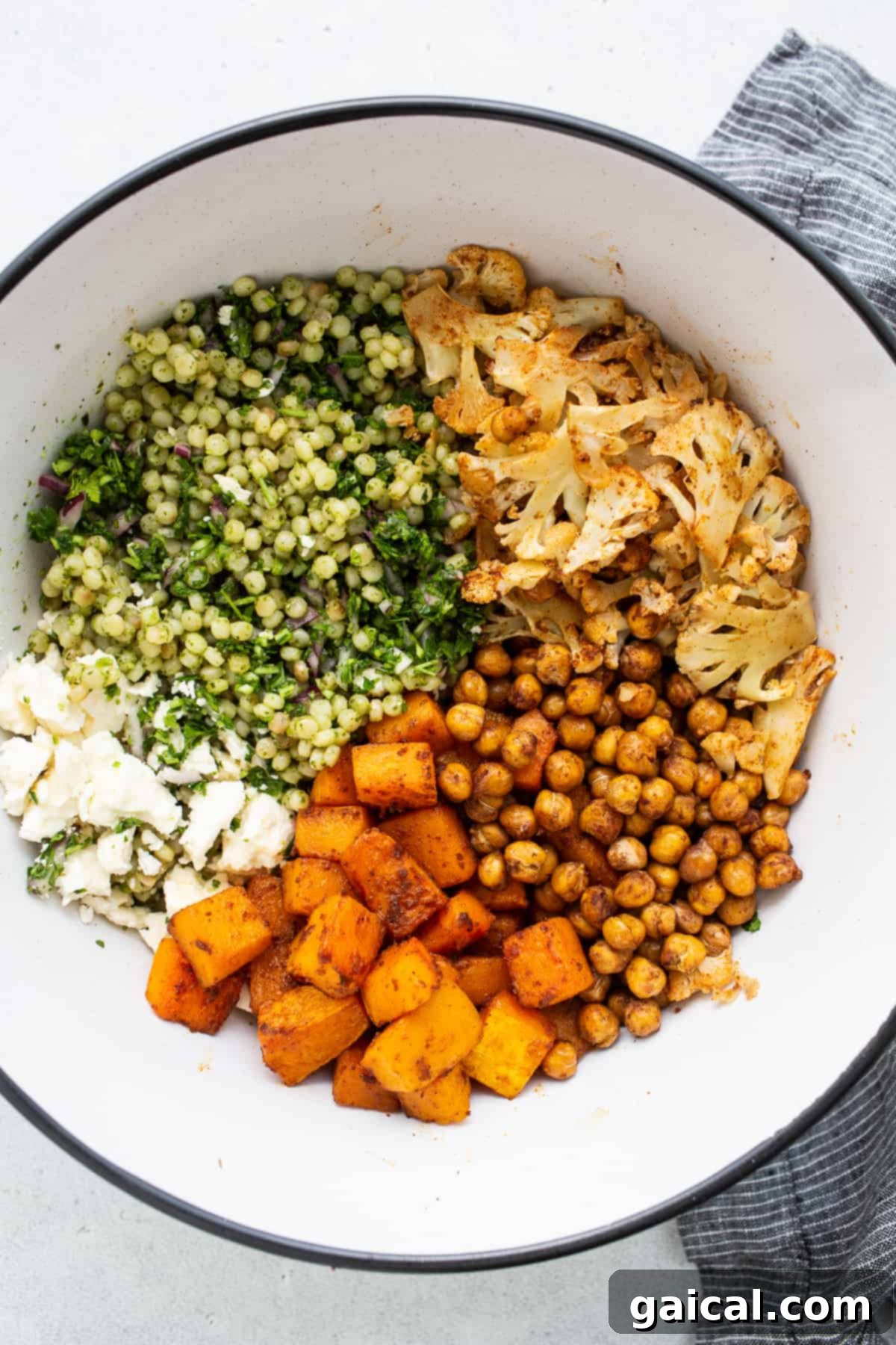 All the vibrant, fresh ingredients for the Israeli couscous salad arranged artfully in a bowl before preparation.