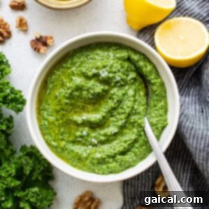 A small bowl filled with vibrant green homemade kale pesto, ready to be used.