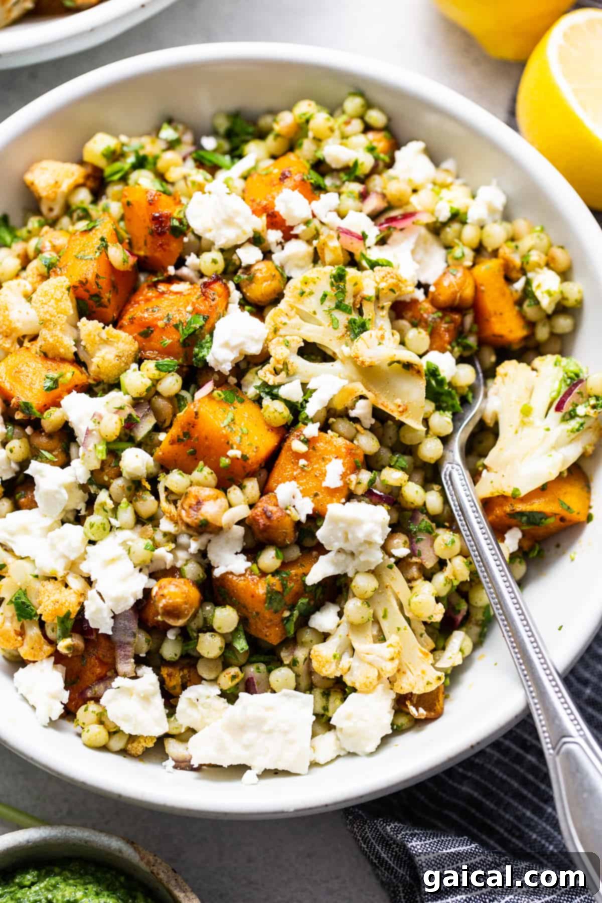 A large serving bowl filled with the complete Israeli couscous salad, ready to be enjoyed, showcasing all its colorful ingredients.