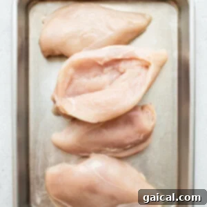Cheesy Spinach Stuffed Chicken 9 Four chicken breasts butterflied in a tray, ready for seasoning.