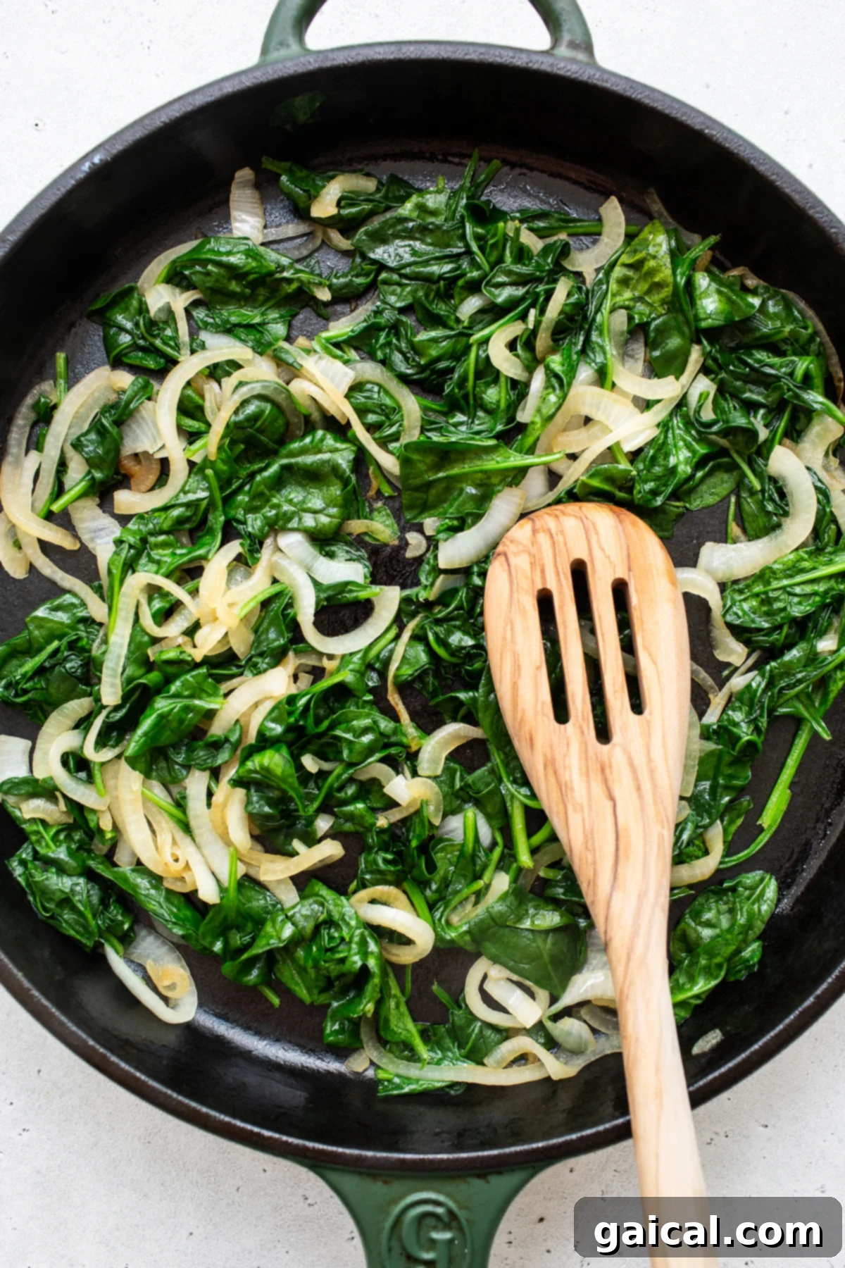 Sauteing Spinach and Onions for Filling Spinach and onions sauteing in a skillet, key steps for the stuffing.