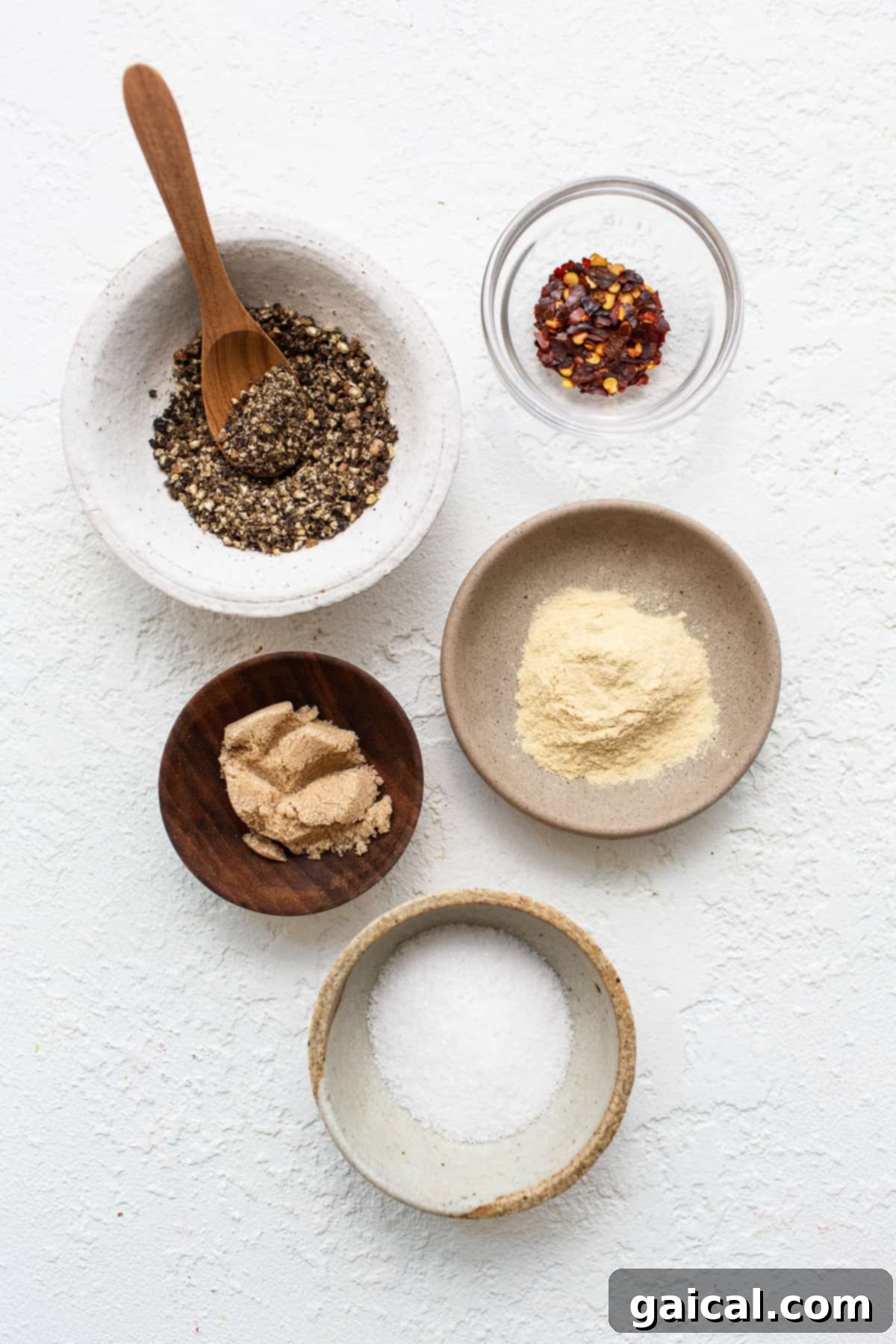 Make your own homemade steak seasoning with just 5 ingredients you likely already have in your spice cupboard, and you’ll be on your way to the most flavorful steak in no time. Individual bowls of garlic powder, red pepper flakes, brown sugar, black pepper, and kosher salt laid out, ready to be combined into a homemade steak seasoning.