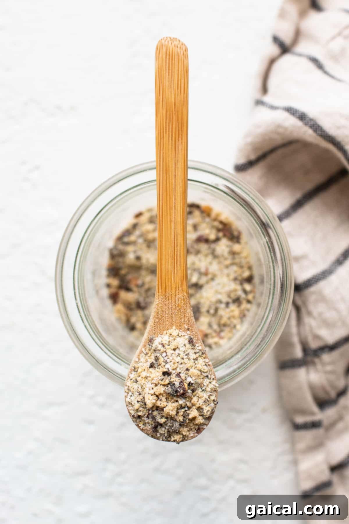 Make your own homemade steak seasoning with just 5 ingredients you likely already have in your spice cupboard, and you’ll be on your way to the most flavorful steak in no time. A wooden spoon holds a scoop of homemade steak seasoning, showcasing its coarse texture and blend of spices.