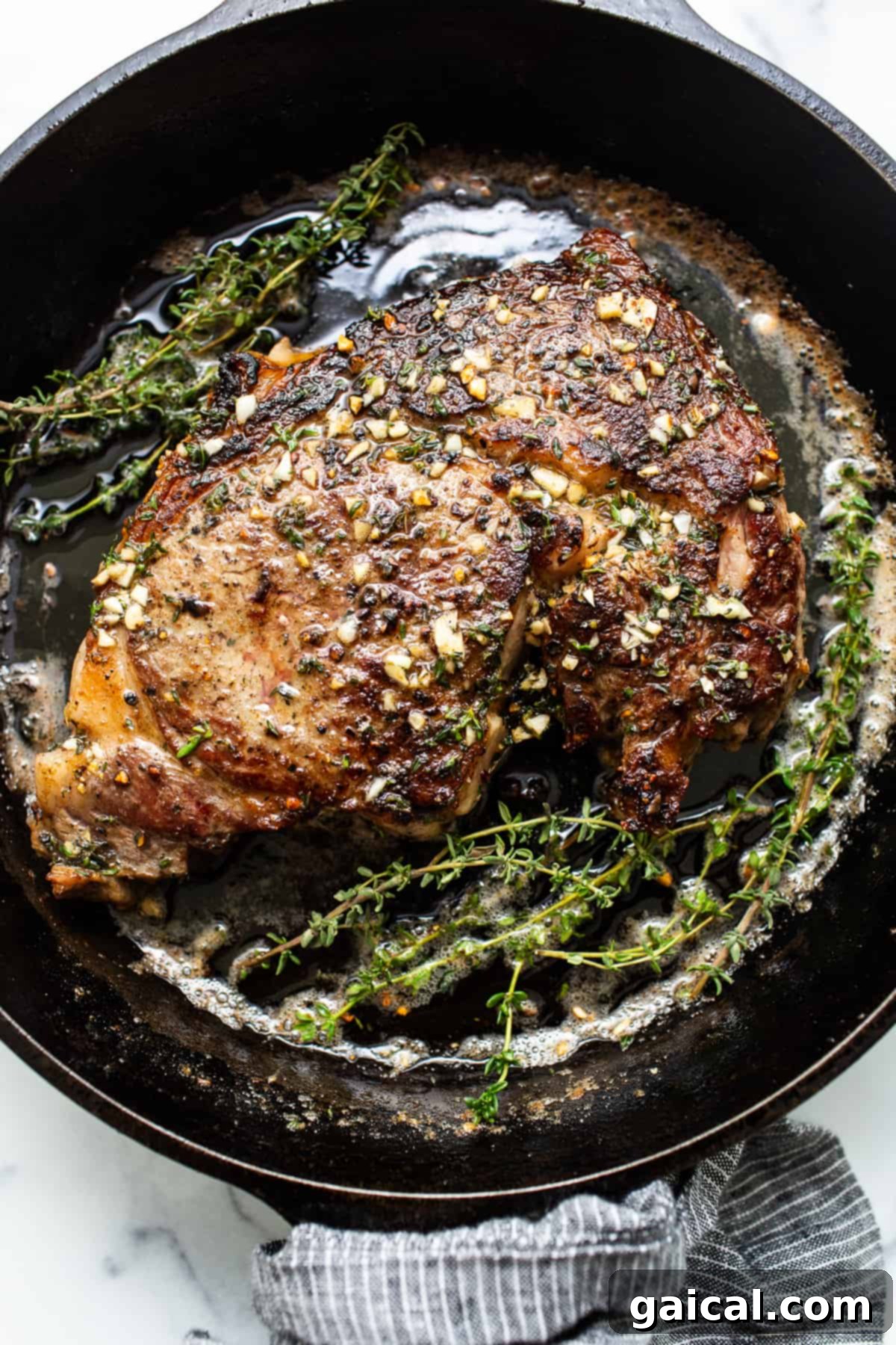 Cast Iron Steak Perfection 2 A perfectly seared cast iron steak in a pan, glistening with butter.