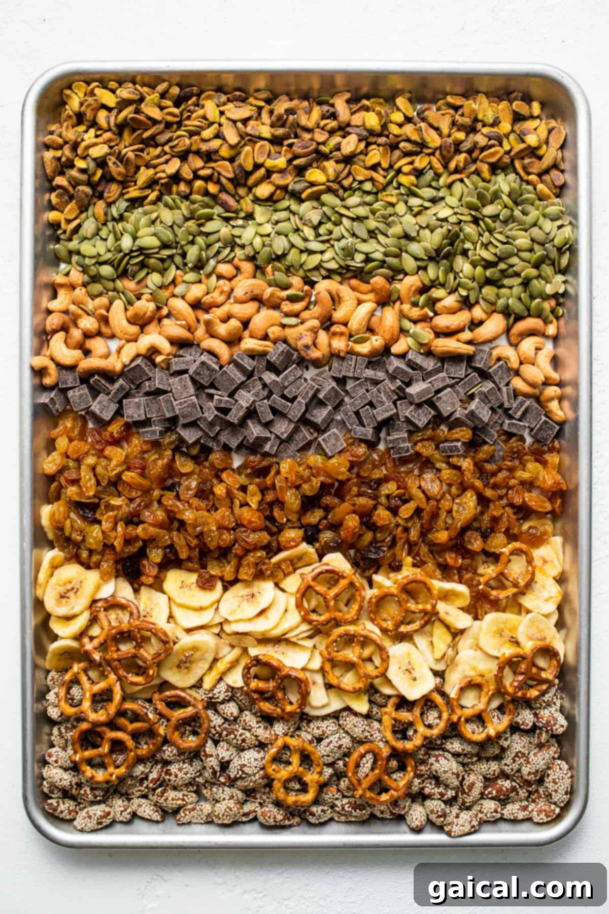 This healthy homemade trail mix is the perfect snack to satisfy all your sweet and salty cravings. Homemade trail mix ingredients on a baking sheet.