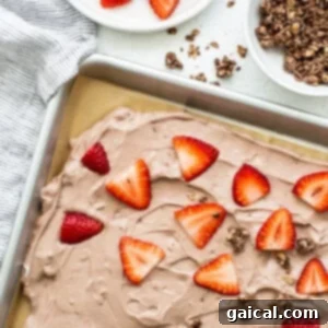 Swirled Strawberry Chocolate Yogurt Bark 5 A sheet of chocolate cake with strawberries and graham cracker crumbs.