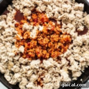 Spicy Korean Ground Chicken Bowls 12 Ground chicken simmering in a rich gochujang sauce in a skillet.