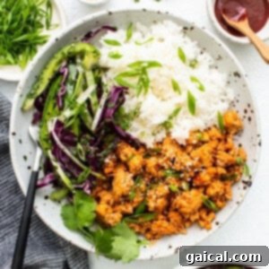 Spicy Korean Ground Chicken Bowls 13 Assembled ground chicken bowls with slaw and rice, garnished with fresh herbs.