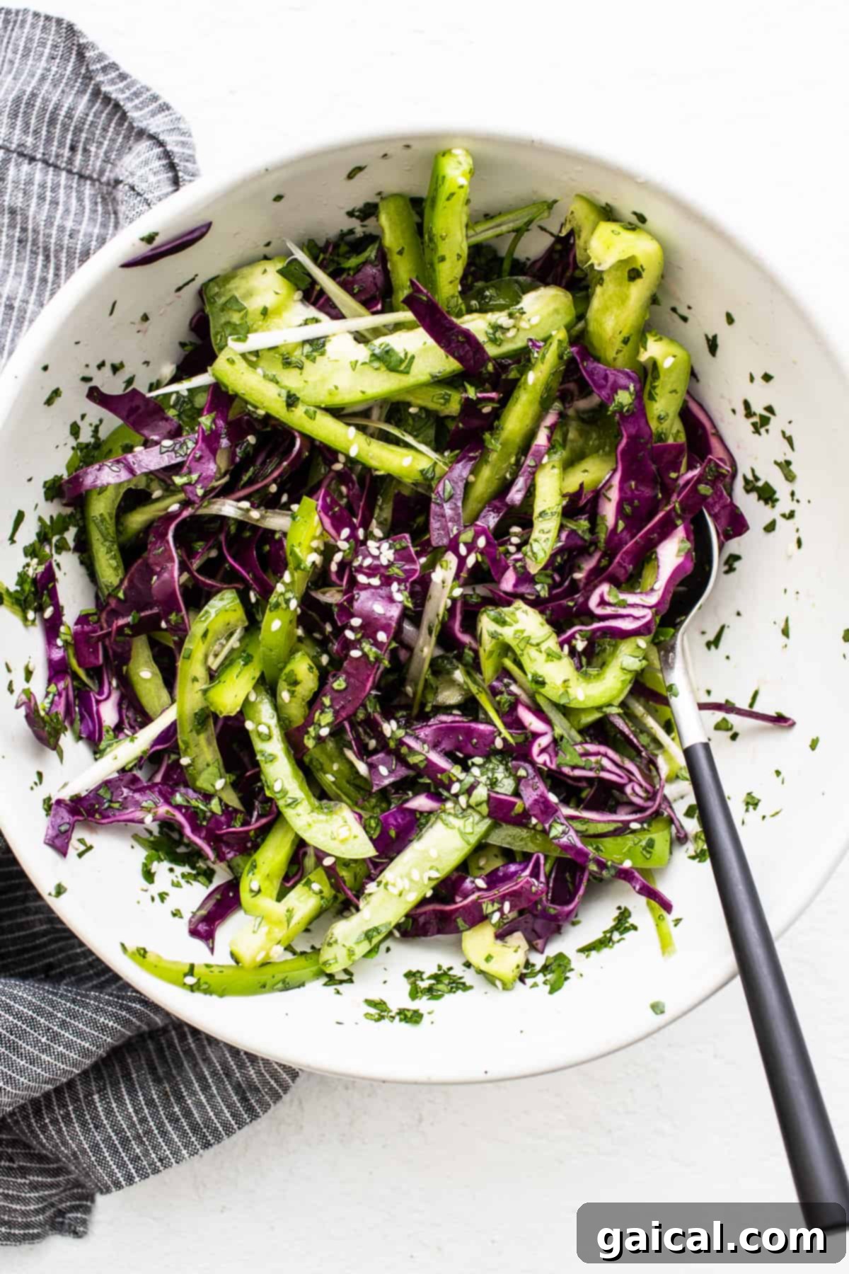 Spicy Korean Ground Chicken Bowls 5 A vibrant vegetable slaw, featuring shredded cabbage and bell peppers, in a large mixing bowl.
