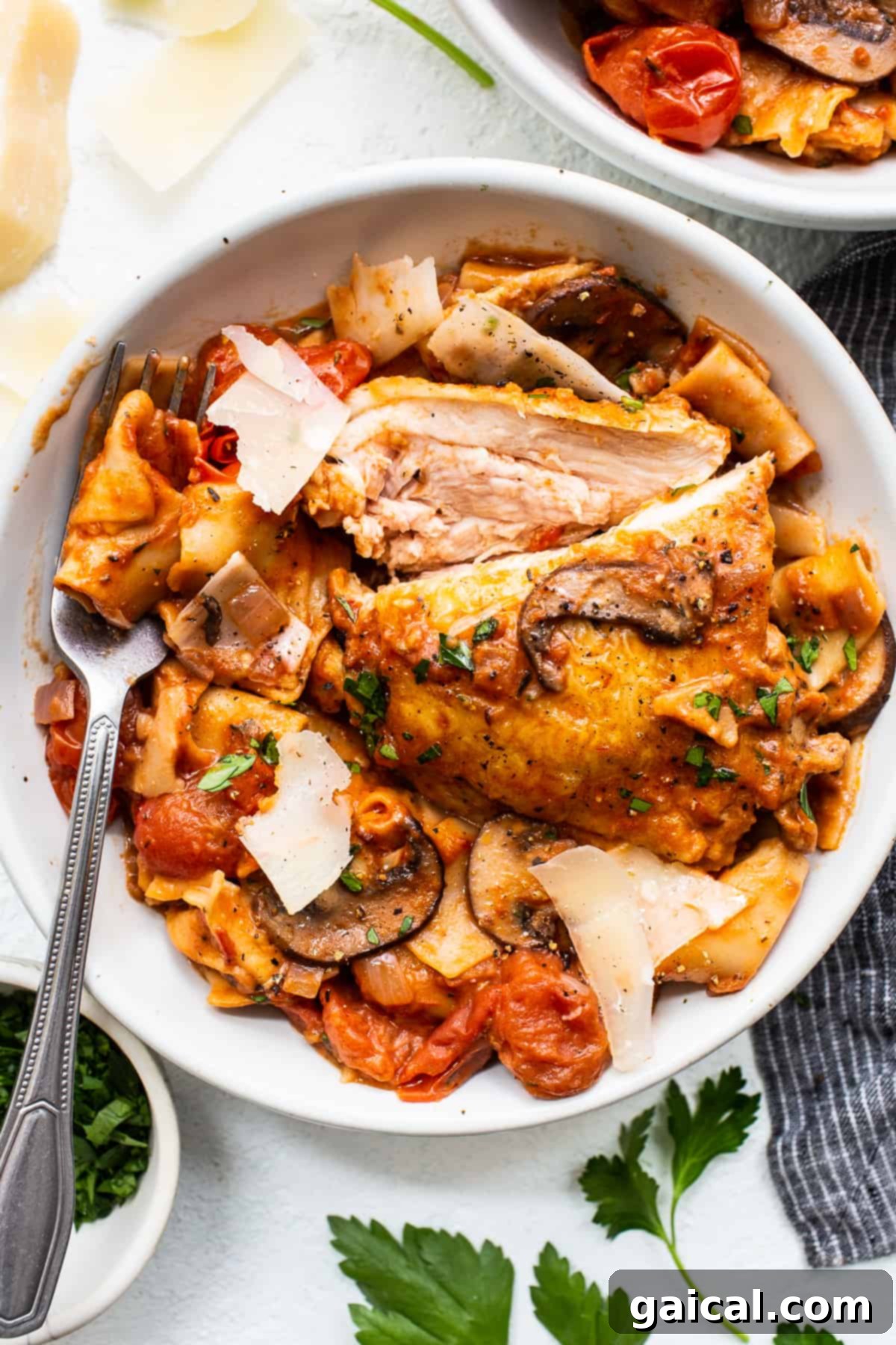 A comforting bowl of one-pot pappardelle pasta, ready to be enjoyed. A hearty serving of one-pot pappardelle with chicken thighs in a white bowl, garnished with fresh herbs.