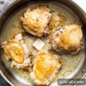 Chicken breasts in a frying pan with butter.