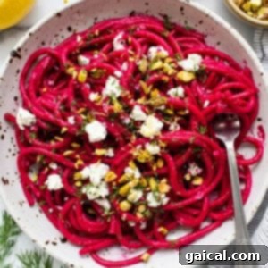 A finished bowl of roasted beet pasta, garnished with fresh toppings.