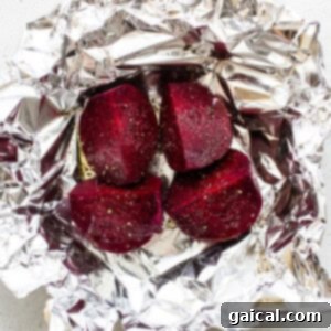 Beets seasoned and wrapped in foil, ready for roasting.