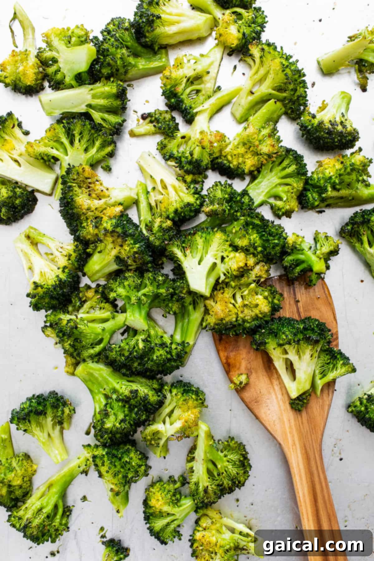 Roasted Broccoli on Spatula Crispy roasted broccoli florets being lifted from a baking sheet with a spatula, showcasing their perfect texture.