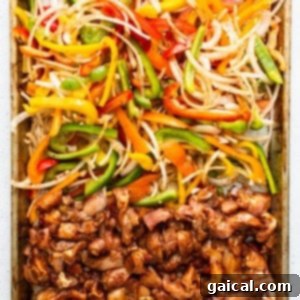 Sheet pan chicken fajitas fresh from the oven, showing crispy chicken and peppers.