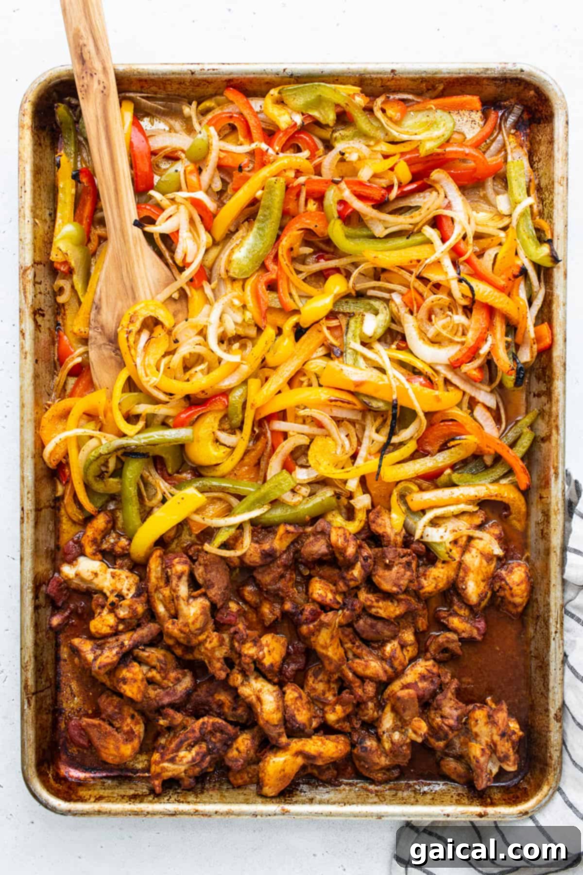 Freshly baked sheet pan chicken fajitas, sizzling hot and ready to be served directly from the baking sheet.