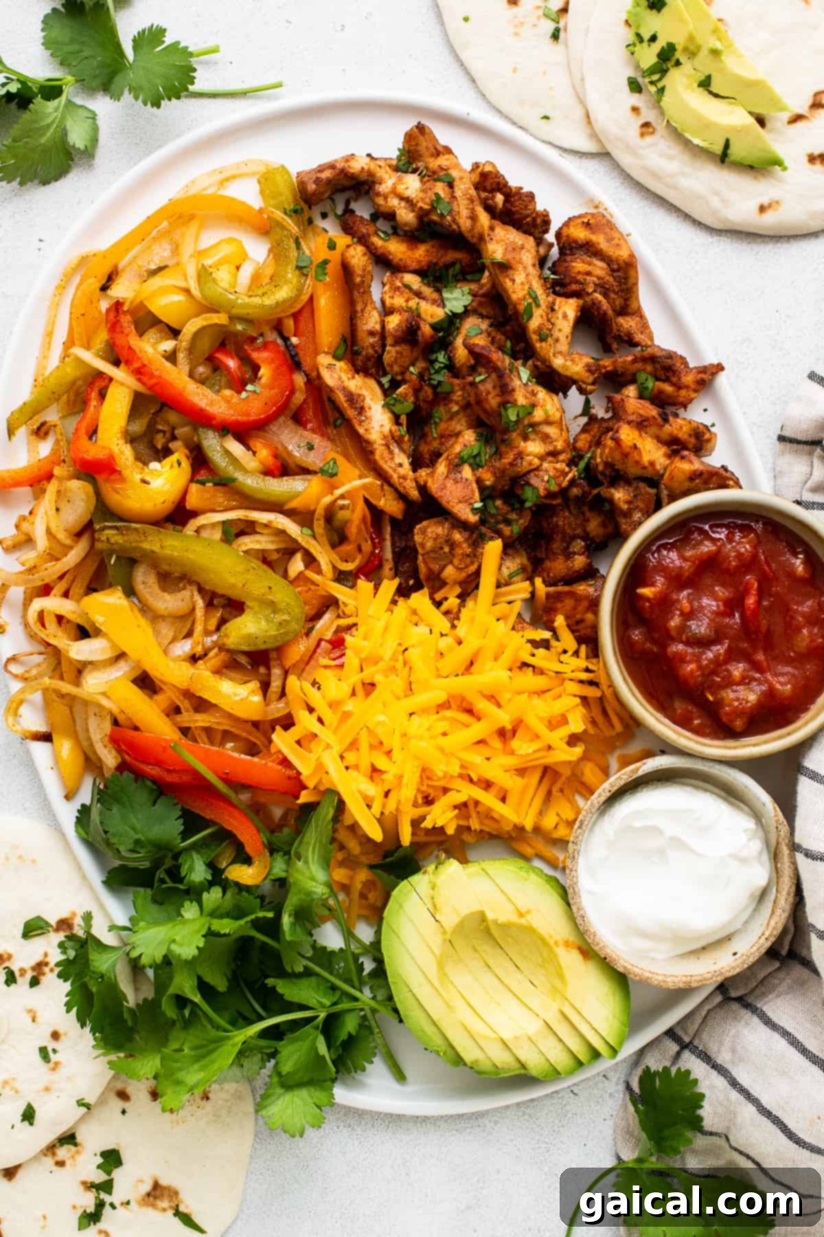 A large platter of cooked chicken fajitas, featuring colorful peppers and onions, ready for a family-style meal.