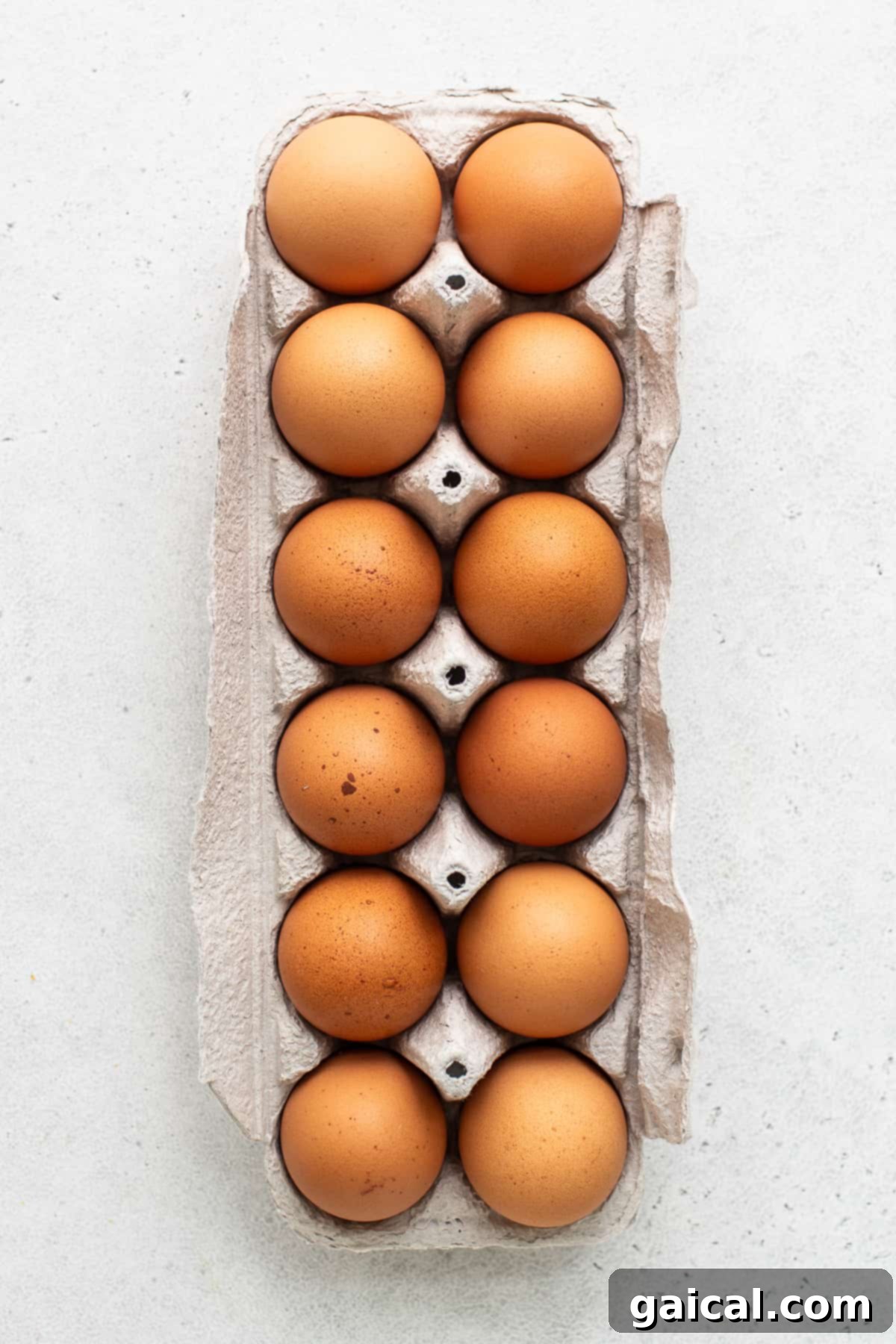 Selecting Fresh Eggs for Air Fryer Preparation A dozen fresh, high-quality large eggs neatly arranged in a brown carton, signifying the start of a perfect air fryer hard boiled egg recipe.