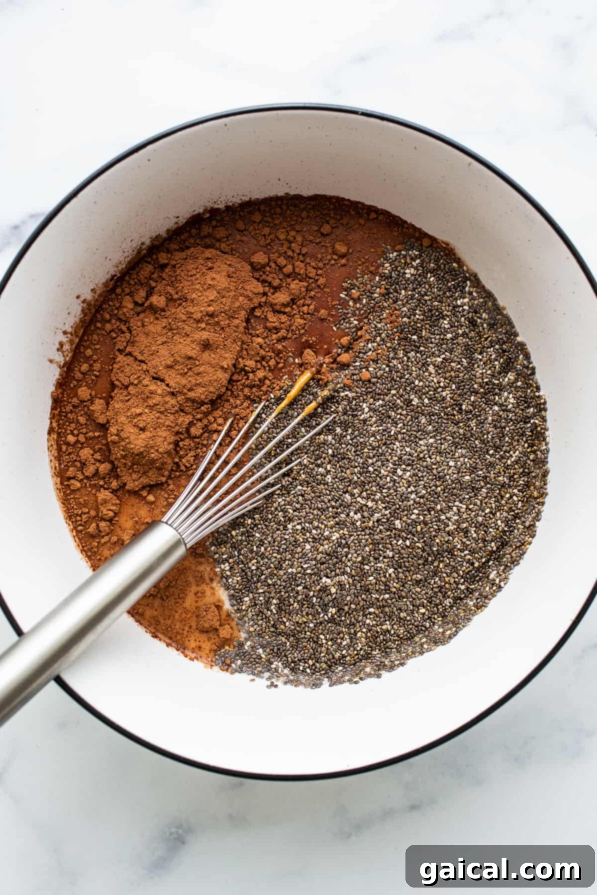 Key Ingredients: Chia Seeds and Cocoa Powder Chia seeds and cocoa powder in a bowl, with a whisk.