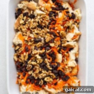 A white baking dish filled with carrots and nuts.