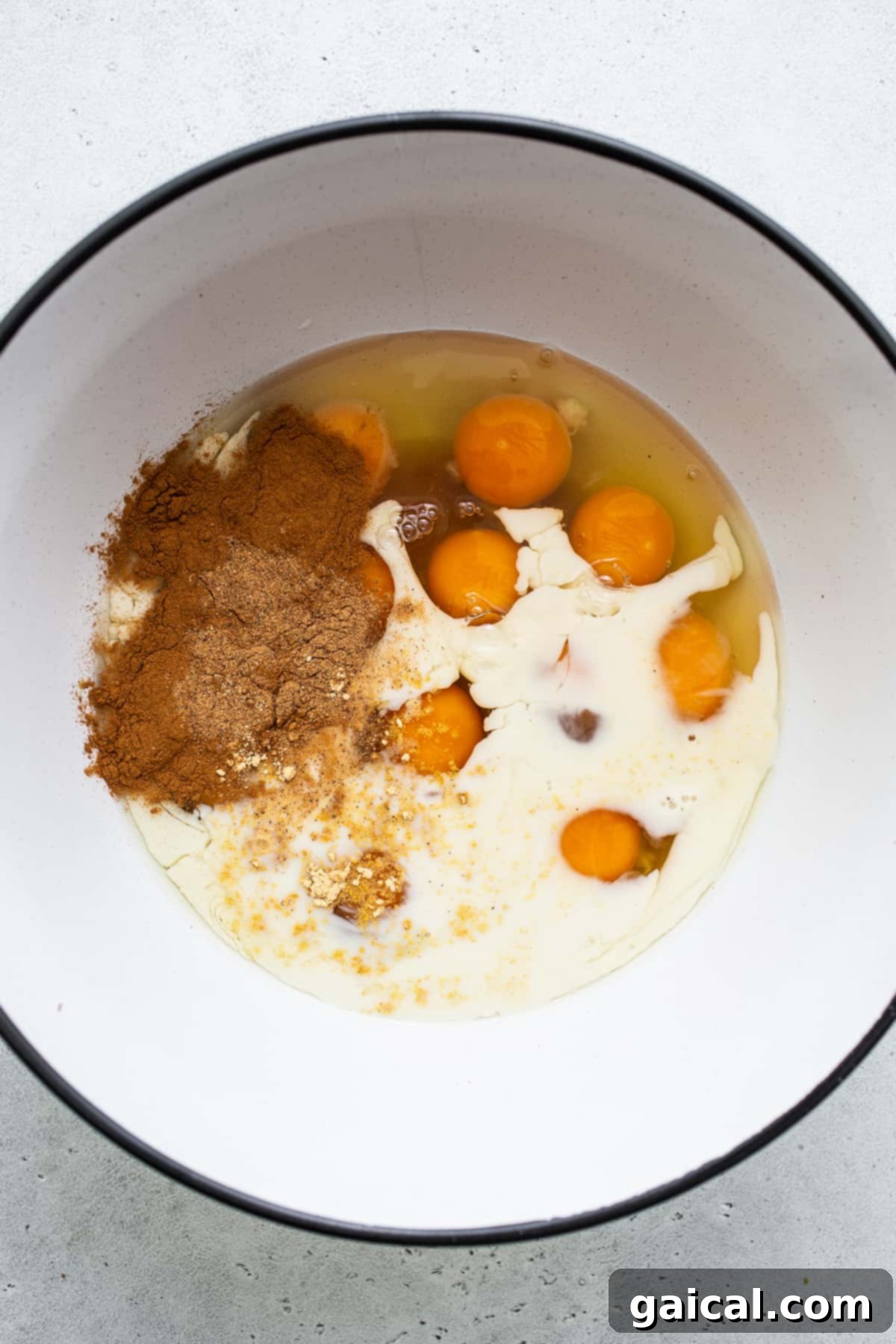 Eggs, milk and cinnamon in a bowl for carrot cake French toast casserole.