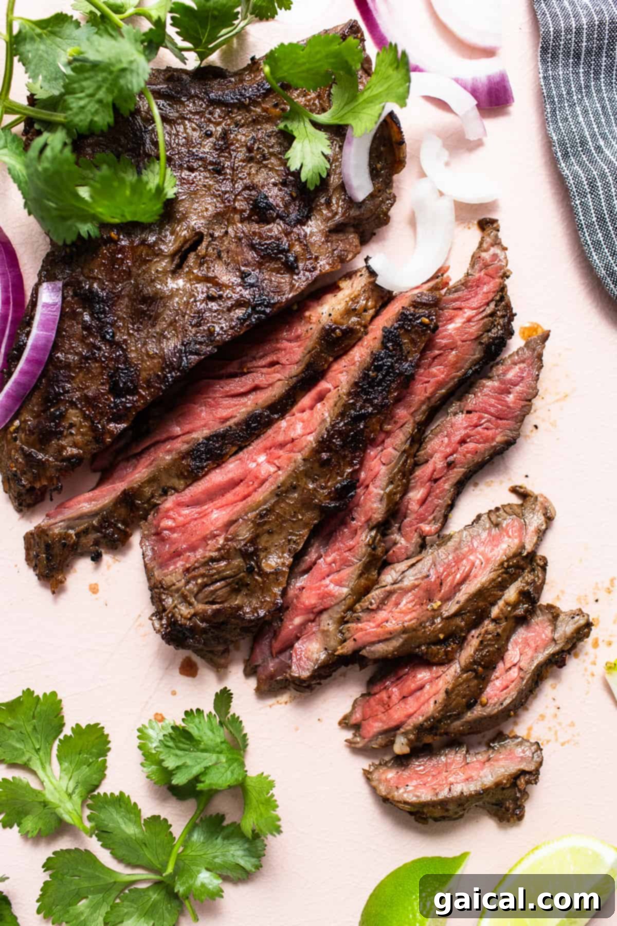 Mastering Skirt Steak Cooking 2 Perfectly sliced pan-seared skirt steak, showcasing its juicy interior, arranged beautifully on a wooden cutting board, garnished with fresh herbs.