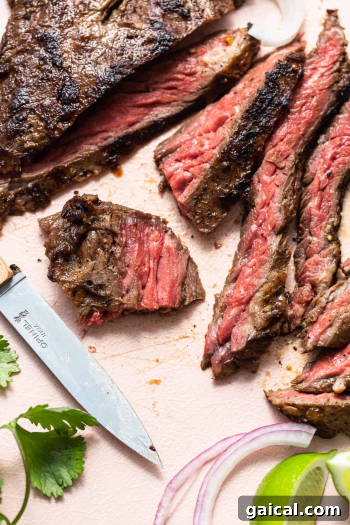 Mastering Skirt Steak Cooking 7 Close-up of perfectly sliced skirt steak next to a chef's knife on a wooden board, ready for serving.