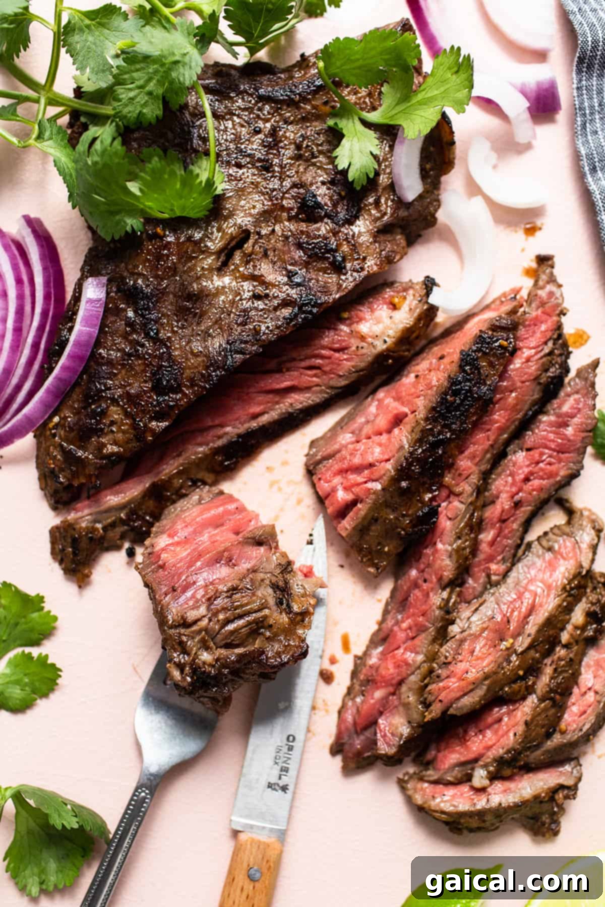 Mastering Skirt Steak Cooking 8 A chef's knife is slicing a piece of pan-seared skirt steak on a wooden cutting board, revealing its tender interior.